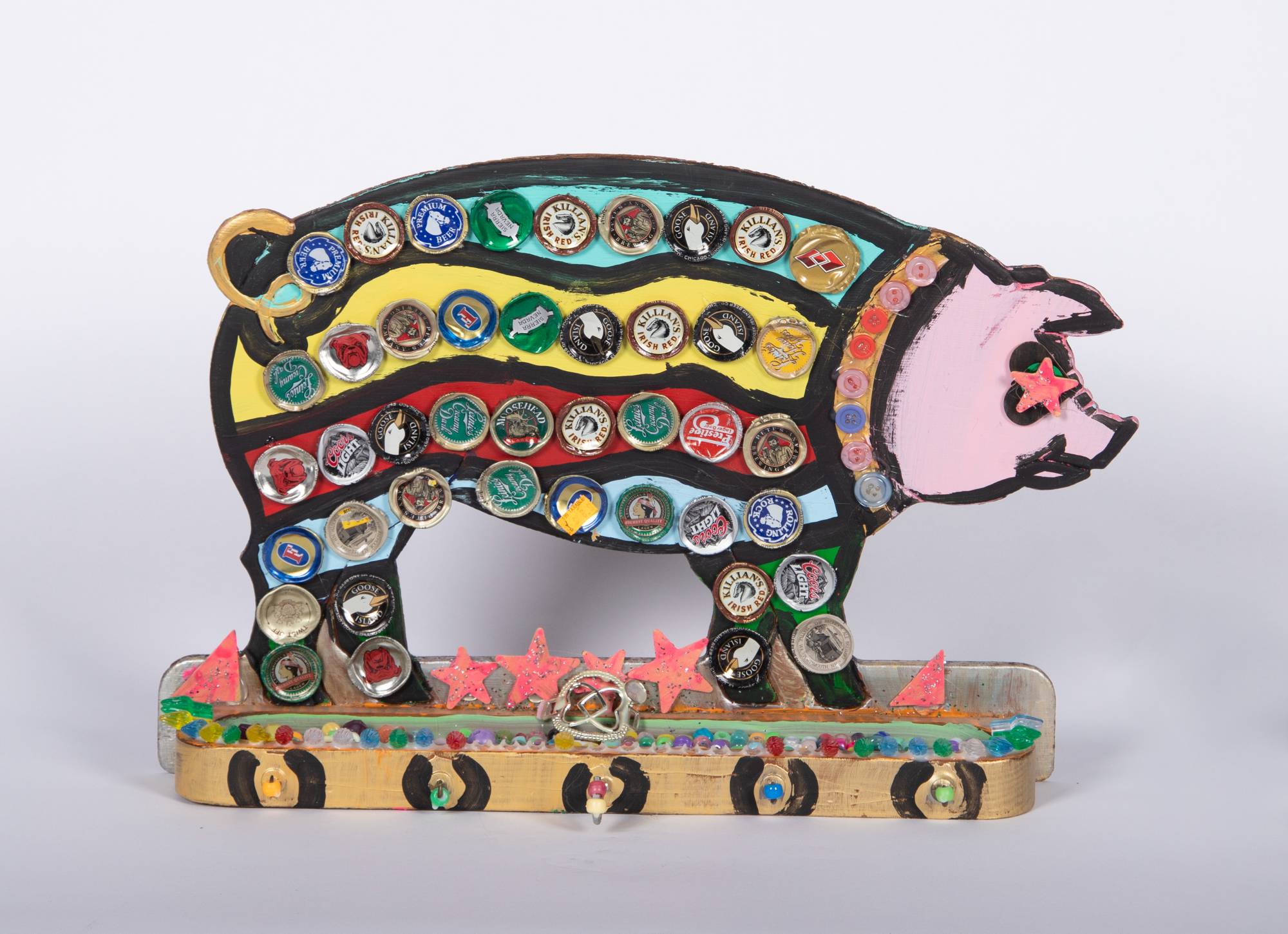 wooden pig colorfully painted and covered in bottle caps